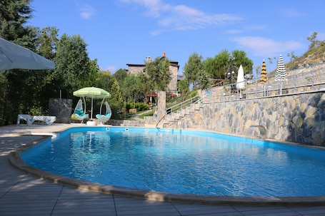 Una piscina al aire libre de temporada, sombrillas