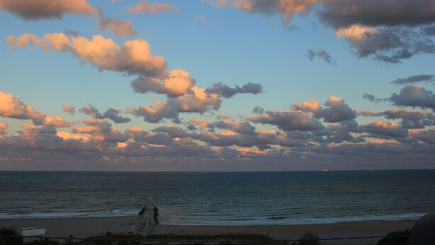 Una playa con cielo despejado y nubes.