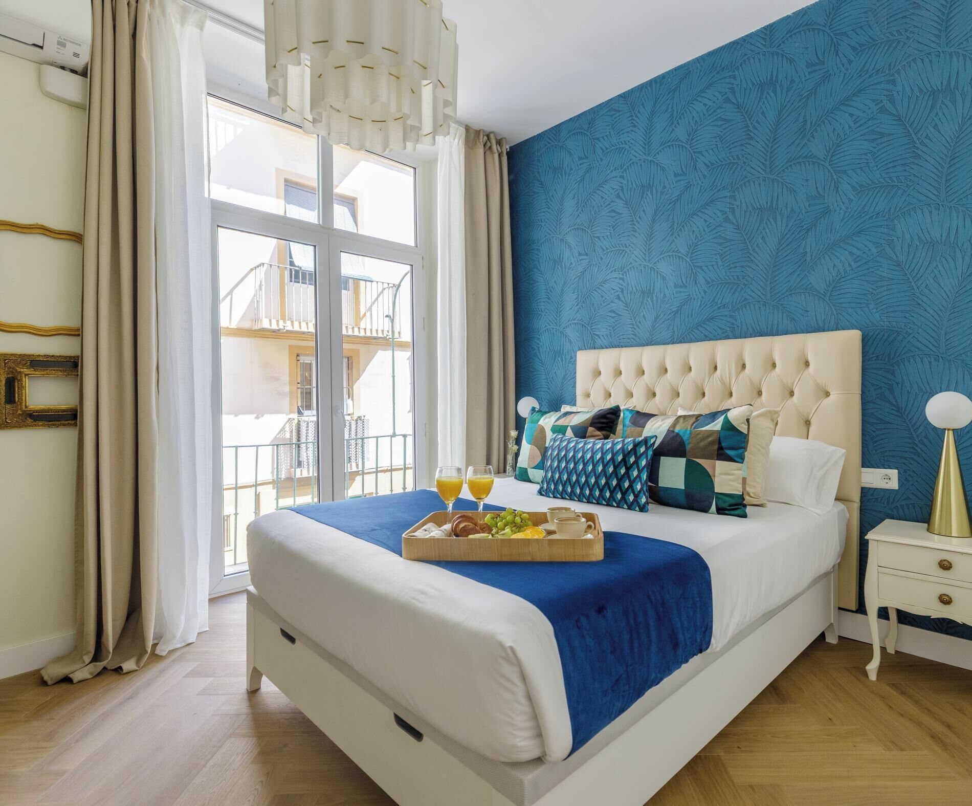 Un dormitorio con una cama grande, una bandeja de desayuno y vistas a un balcón.