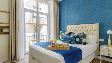 Un dormitorio con una cama grande, una bandeja de desayuno y vistas a un balcón.