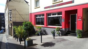 Un hotel con fachada roja y un letrero que dice "HOTEL LE CAMBRONNE".