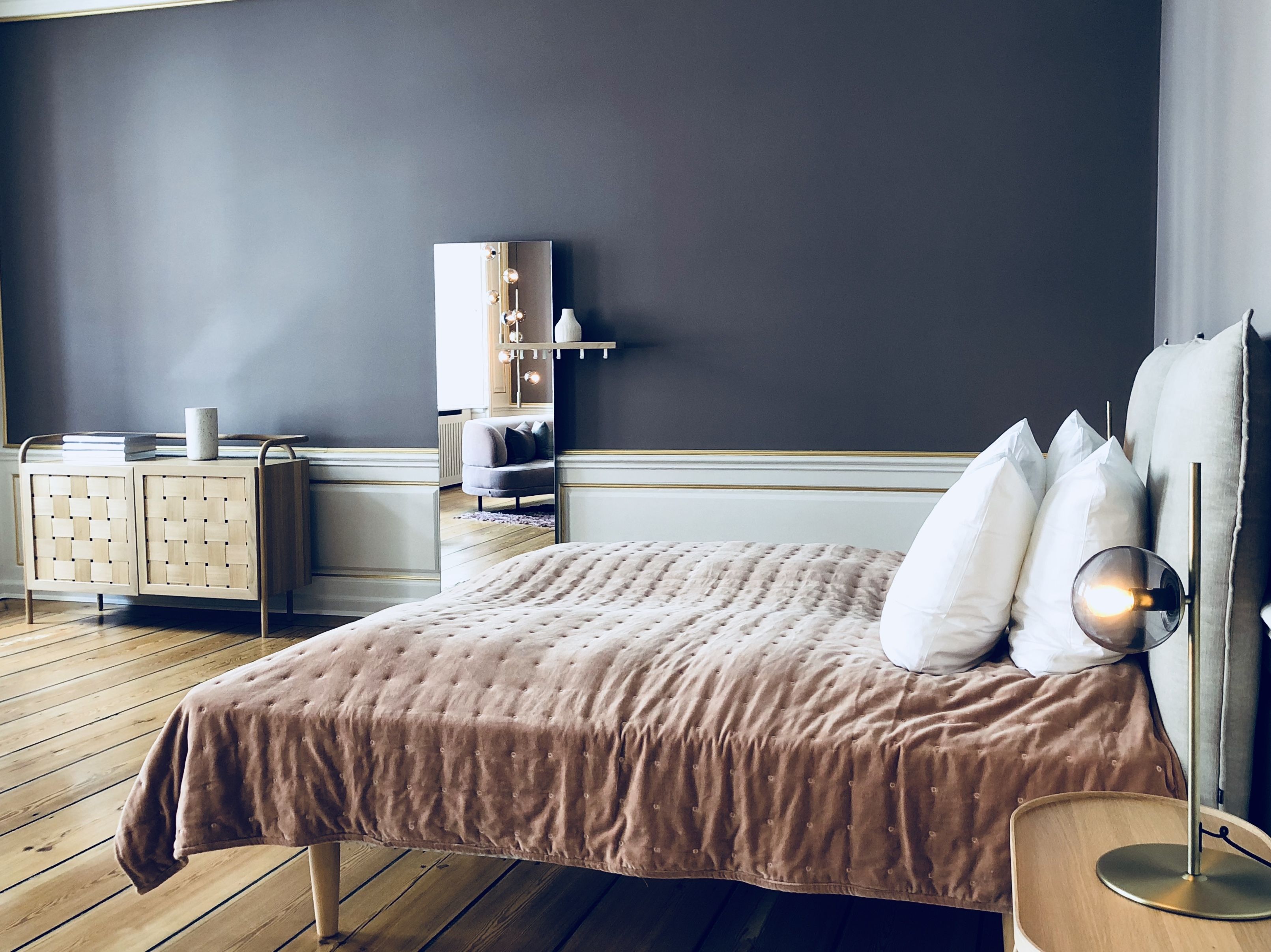 Une chambre à coucher avec un lit, une table de chevet et une commode.