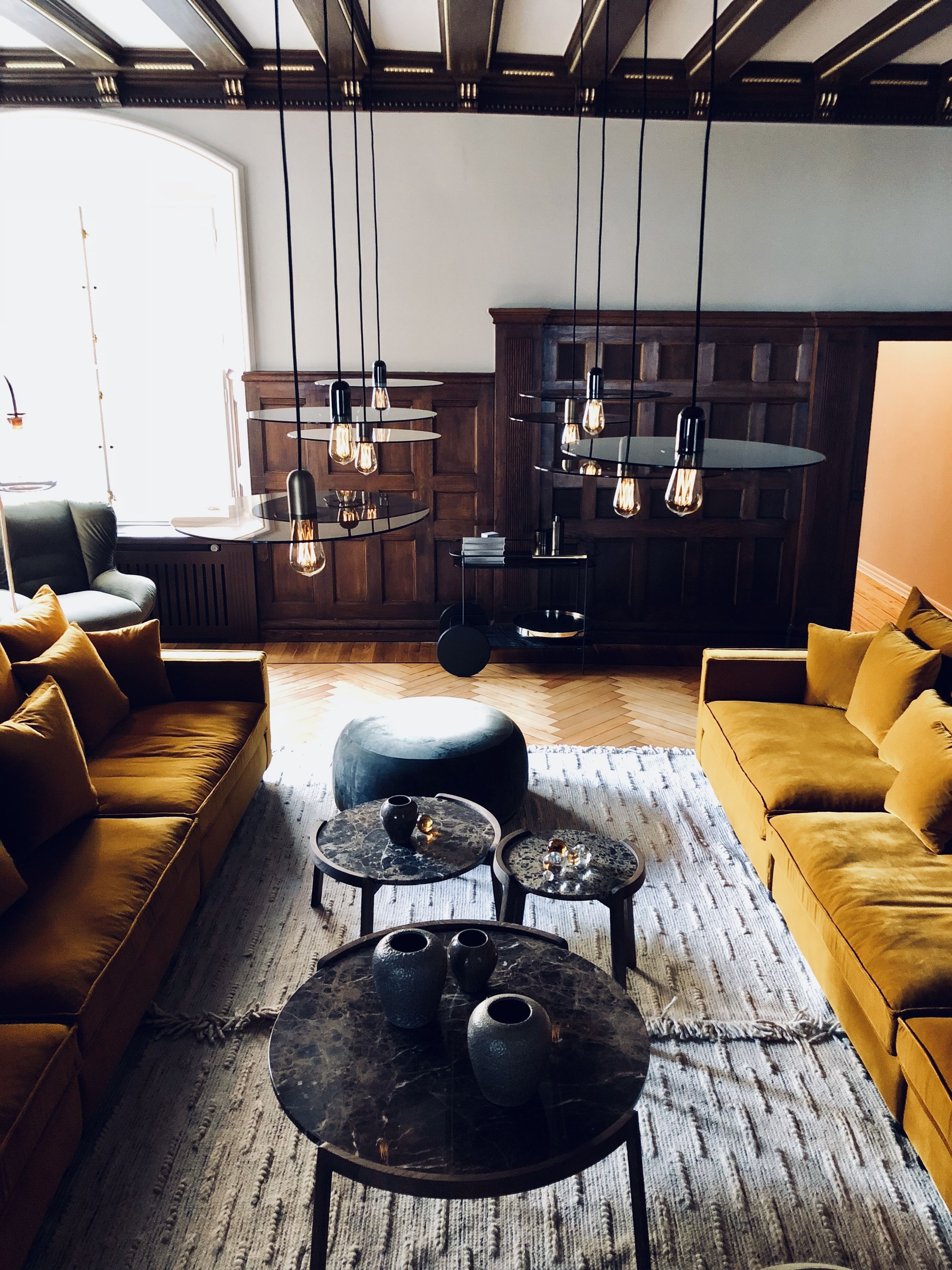 A modern living room with a sofa, coffee table, and pendant lights.