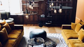 A modern living room with a sofa, coffee table, and pendant lights.
