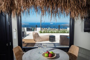 Un comedor con mesa, sillas y vistas al mar.