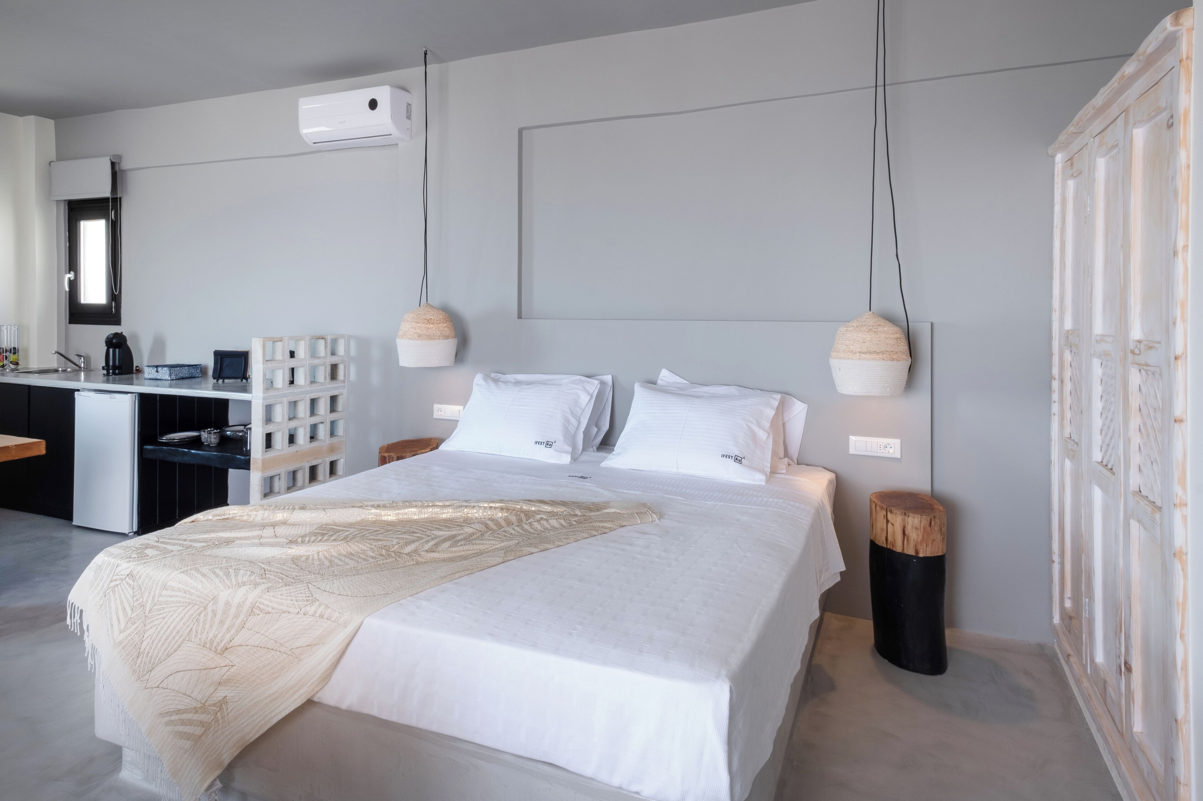 Ein modernes Schlafzimmer mit einem großen Bett, Nachttischen, einem Schreibtisch und einem Kleiderschrank.