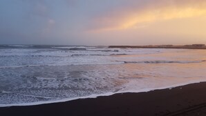 A beach with waves and a sunset. - Black beach cottage (Sveitarfélagid Ölfus)