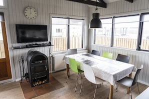 Relax in this spacious living area with a large flat-screen TV, fireplace, and dining table for four.