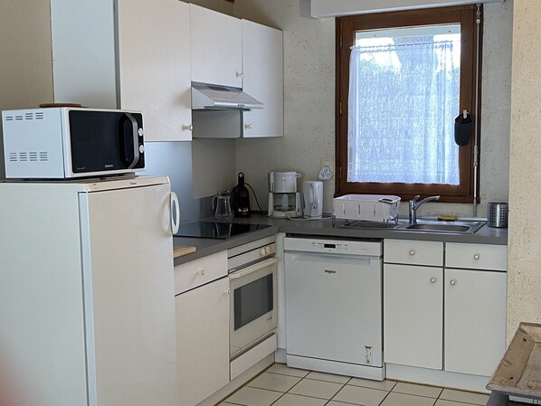 A compact kitchen with white cabinets, a microwave, a coffee maker, and a dishwasher. - KREISKER 4 - Maison Jumelée, Jardin - CA6010 (Carnac)