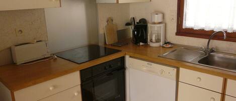 A compact kitchen with a toaster, a coffee maker, a sink, and a dishwasher.