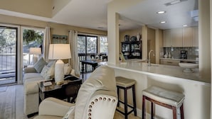 A spacious living area with a sofa, a dining table, and a kitchen with modern appliances. - 102 Beachwalk – Your Coastal Retreat Just Moments from the Shore! (Hilton Head Island)