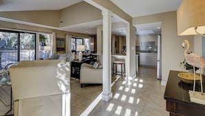 A spacious living area with a sofa, a dining table, and a kitchen in the background. - 102 Beachwalk – Your Coastal Retreat Just Moments from the Shore! (Hilton Head Island)