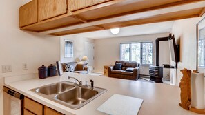 Enjoy a warm and inviting space with a kitchen island, dishwasher, and cozy living area with a fireplace.