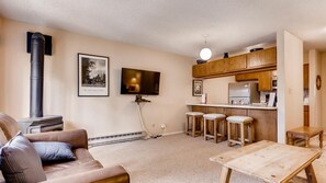 Cozy living space with a modern kitchenette, comfortable seating area, and a wall-mounted TV.
