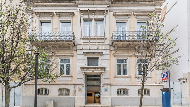 A historic building with a symmetrical facade, large windows, and balconies with ornate railings. - HI Lisboa – Pousada de Juventude - Hostel (Lisbon)