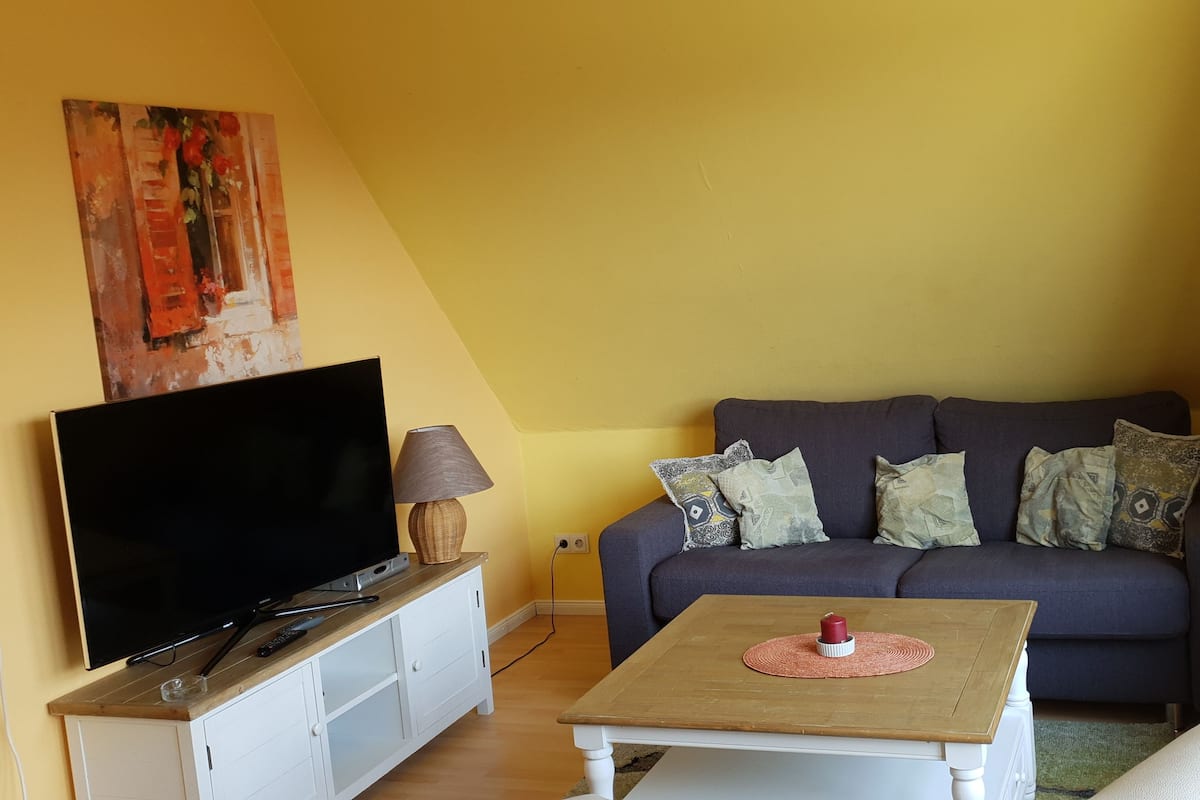 A living room with a TV, sofa, and coffee table.