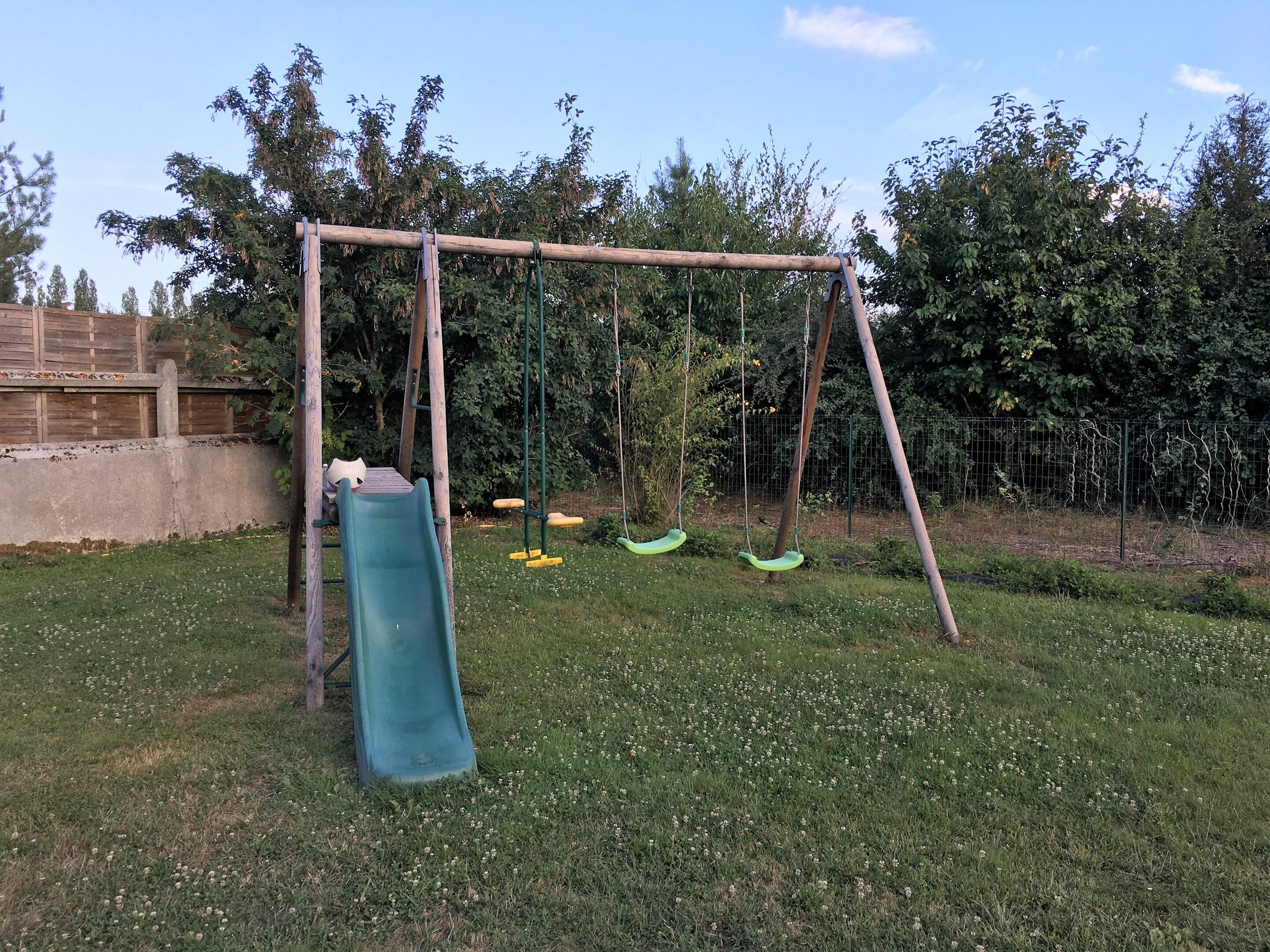Un parque infantil con un tobogán y columpios.