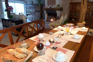 Una mesa de desayuno lista, con pan, huevos y bebidas.