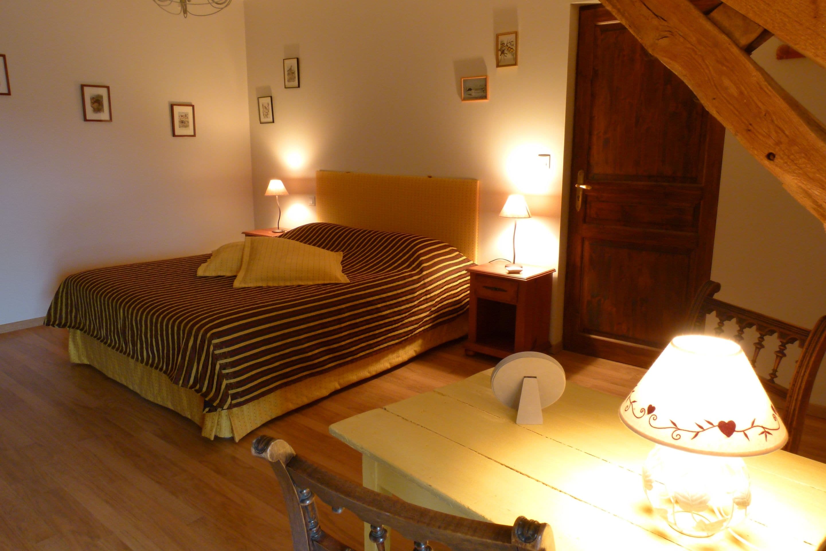 Ein Schlafzimmer mit einem Bett, Nachttischen, einer Lampe und einer Tür.