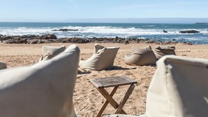 A beach with a small wooden table and several beige cushions. - HI Porto – Pousada de Juventude - Hostel (Porto)