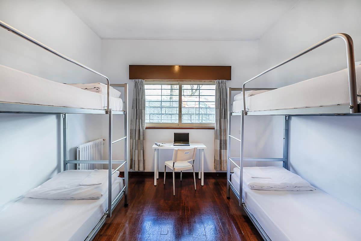 Une chambre avec deux lits superposés, un bureau et une chaise.