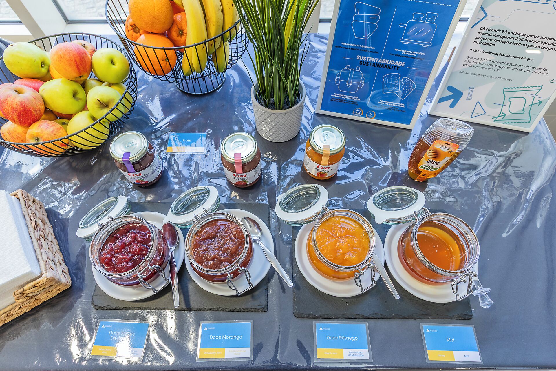 Ein Tisch mit verschiedenen Speisen, darunter Obst, Marmeladen und Honig.