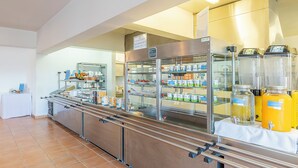 Un espace buffet avec des présentoirs en libre-service, des vitrines réfrigérées et un distributeur de boissons.