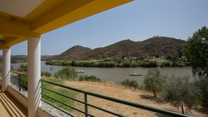 A balcony with a view of a river, boats, and hills. - HI Alcoutim – Pousada de Juventude - Hostel (Alcoutim)