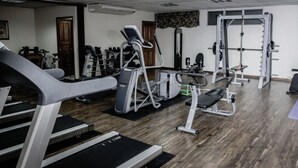 Ein Fitnessstudio mit Laufbändern, Crosstrainern und Gewichten.