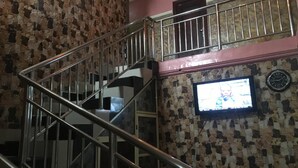 A staircase with a stone wall and a television mounted on it. - Marble Hill Hotel (Lagos)