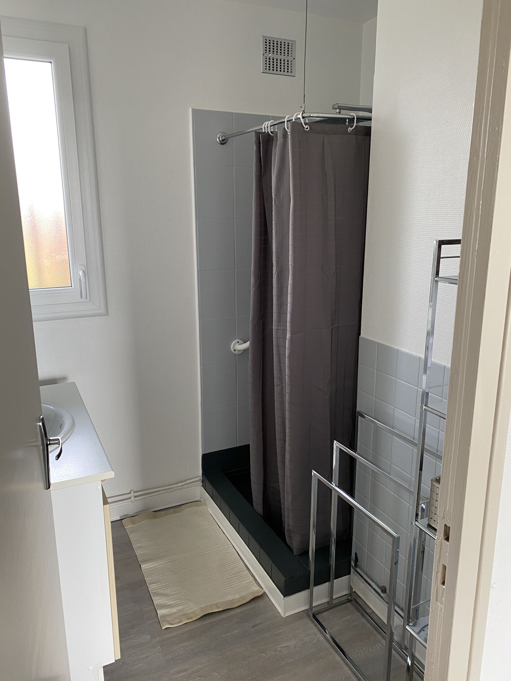 A small bathroom with a shower, a toilet, and a sink.
