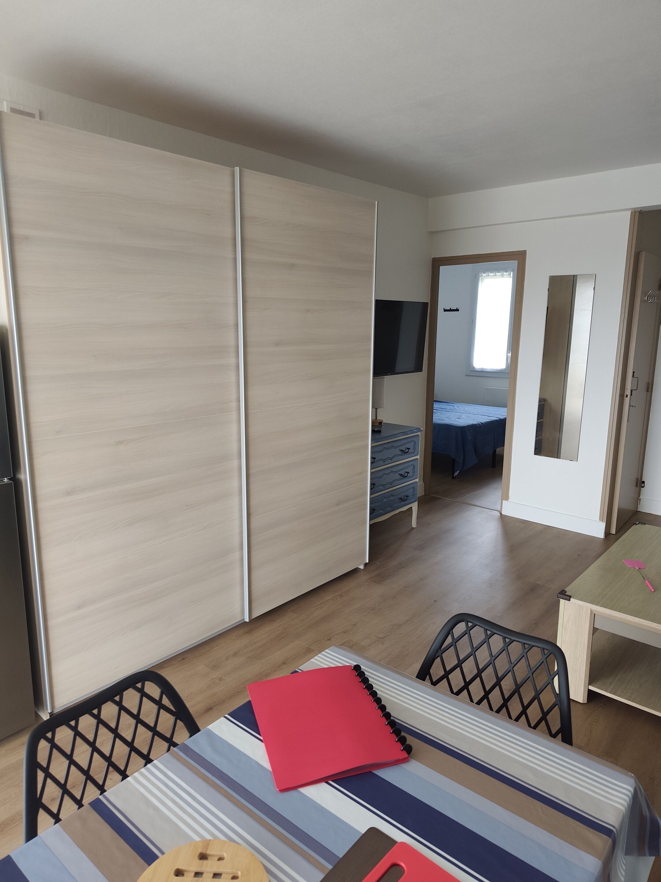 Een kamer met een bed, een televisie, een bureau en een stoel.