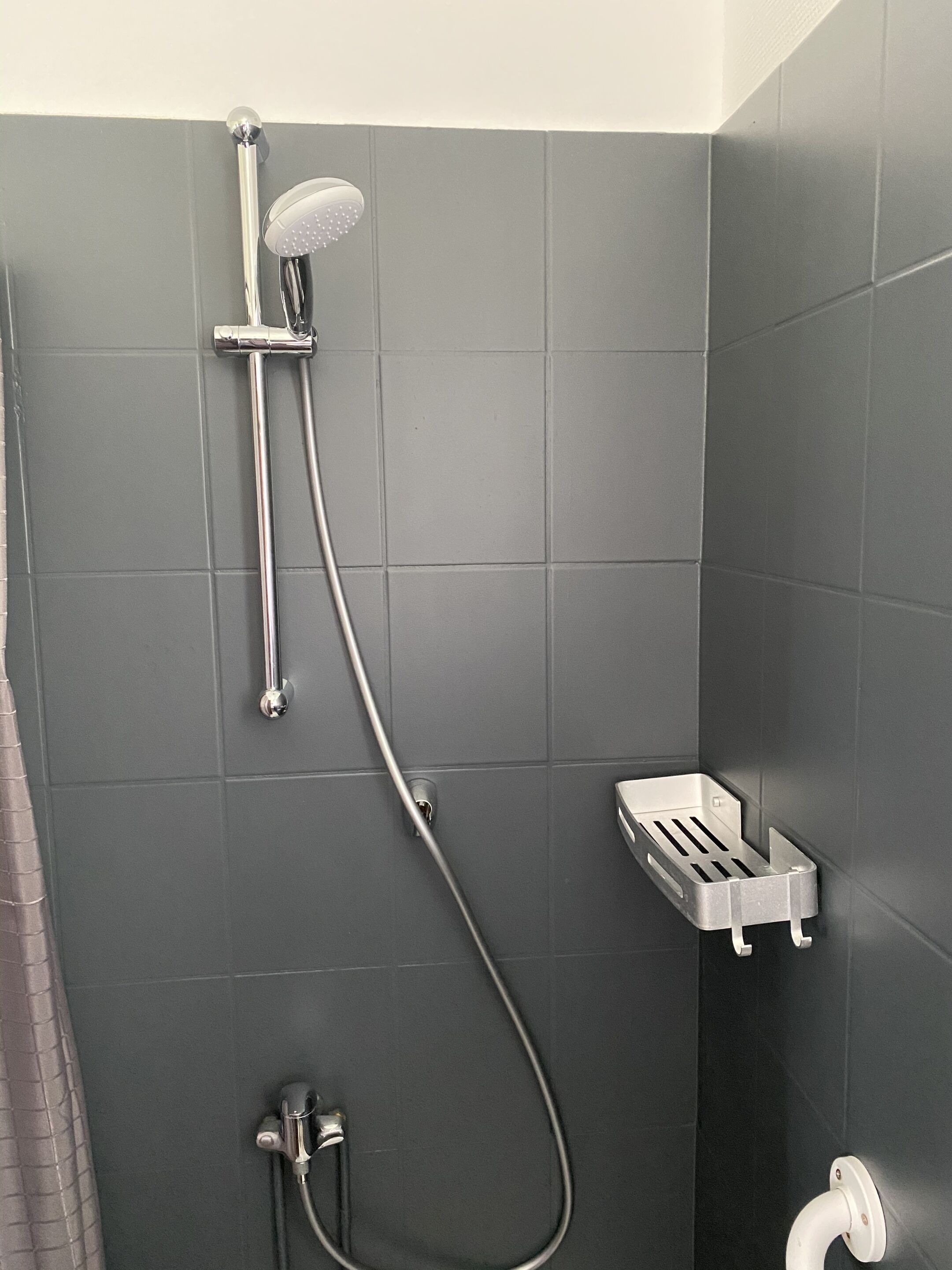 Una ducha con cabezal de ducha de mano y grifo empotrado.