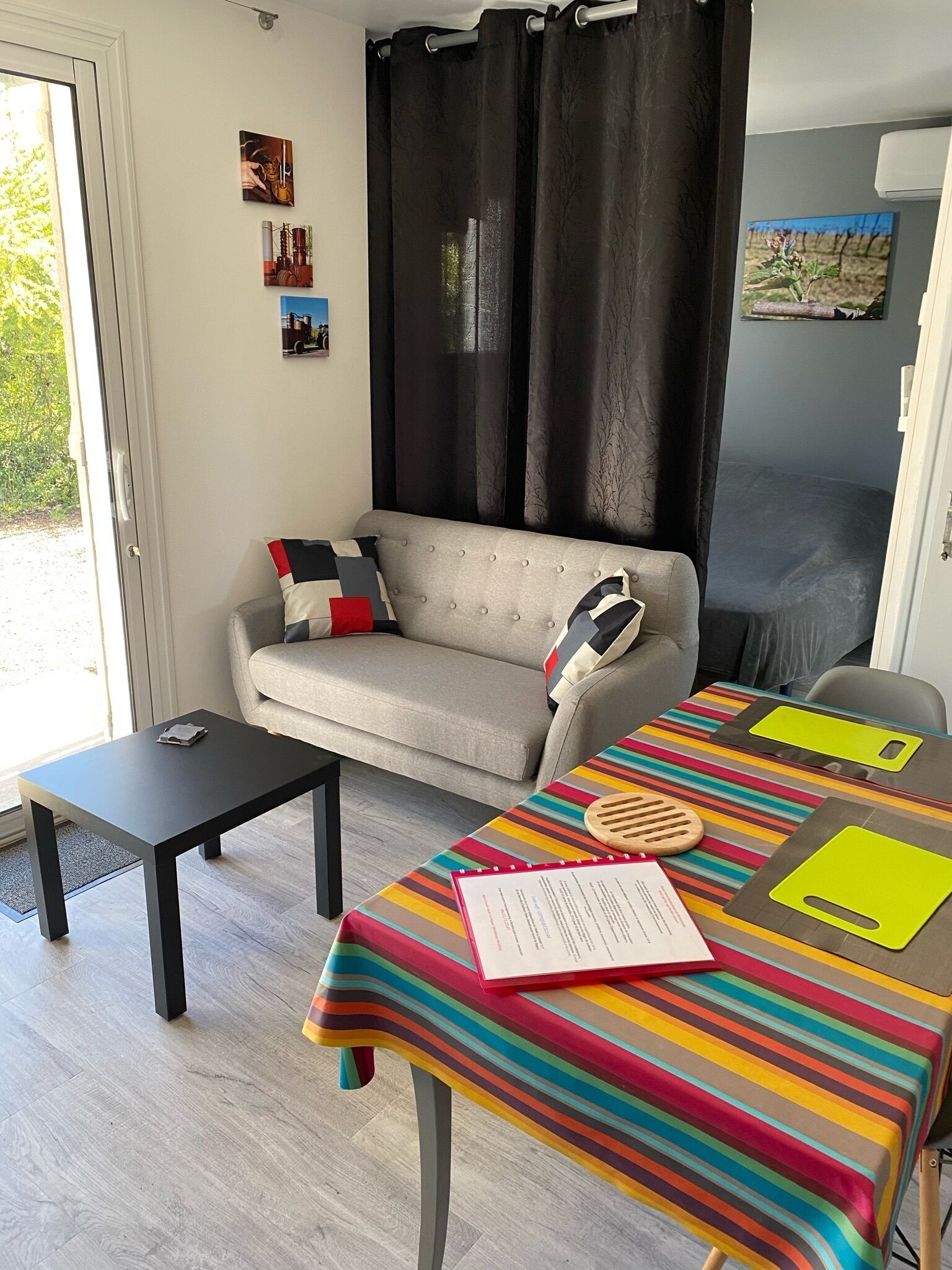 A cozy living area with a sofa, a small table, and a colorful striped tablecloth.