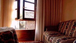 A room with a bed, a window, and a table. - Casa Florentina (Cabrales)