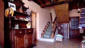 A spacious living room with a wooden staircase, a large wooden cabinet, and a tiled floor. - Casa Florentina (Cabrales)