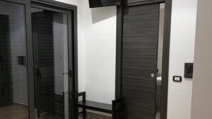 Un dormitorio con una cama, un televisor montado en la pared y un armario con puerta corredera.