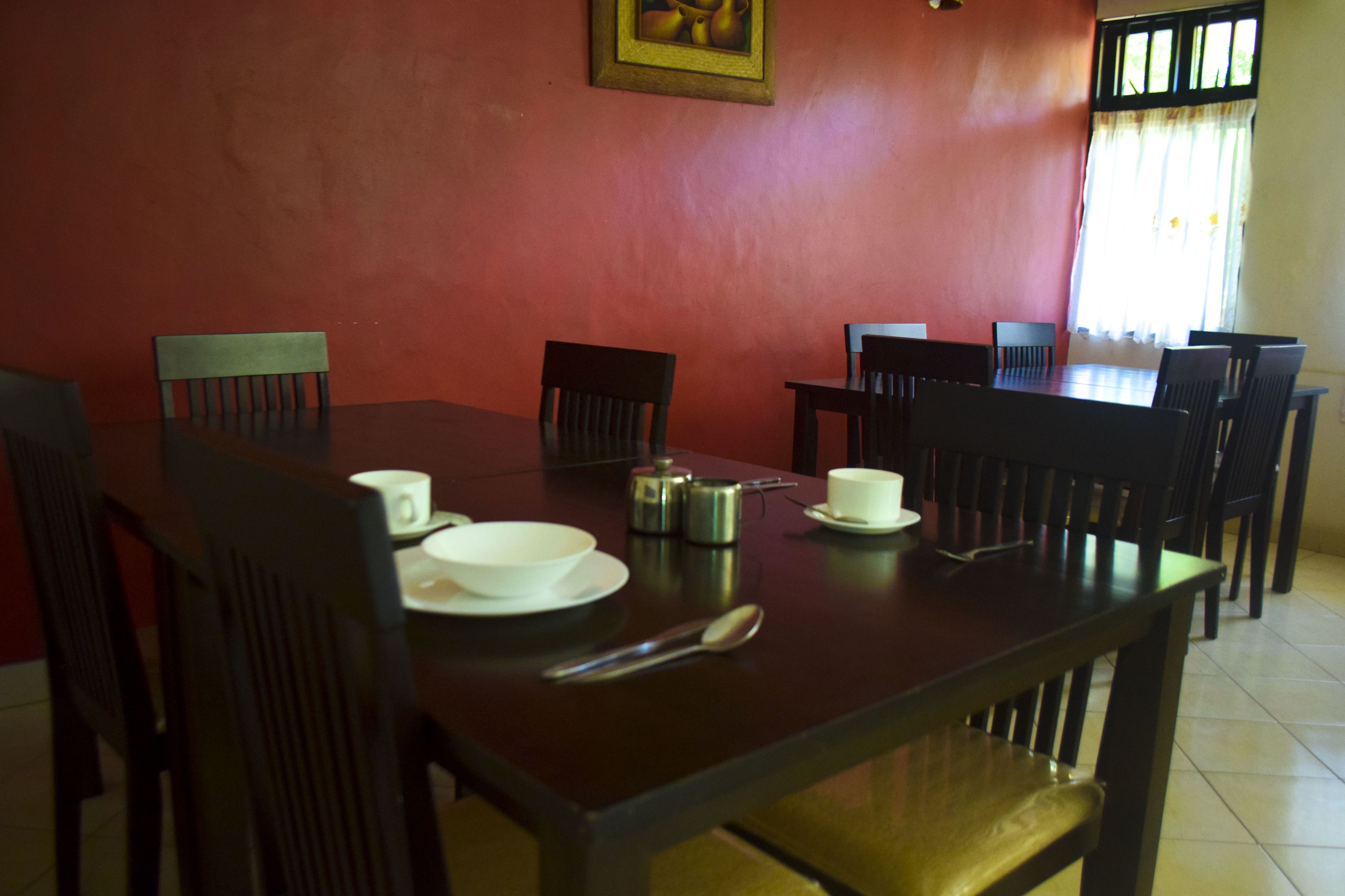 Un comedor con una mesa de madera, sillas y un cuadro en la pared.