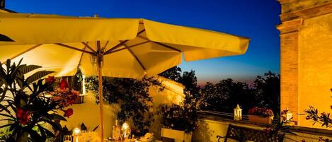 An outdoor dining area with tables, chairs, and yellow umbrellas.