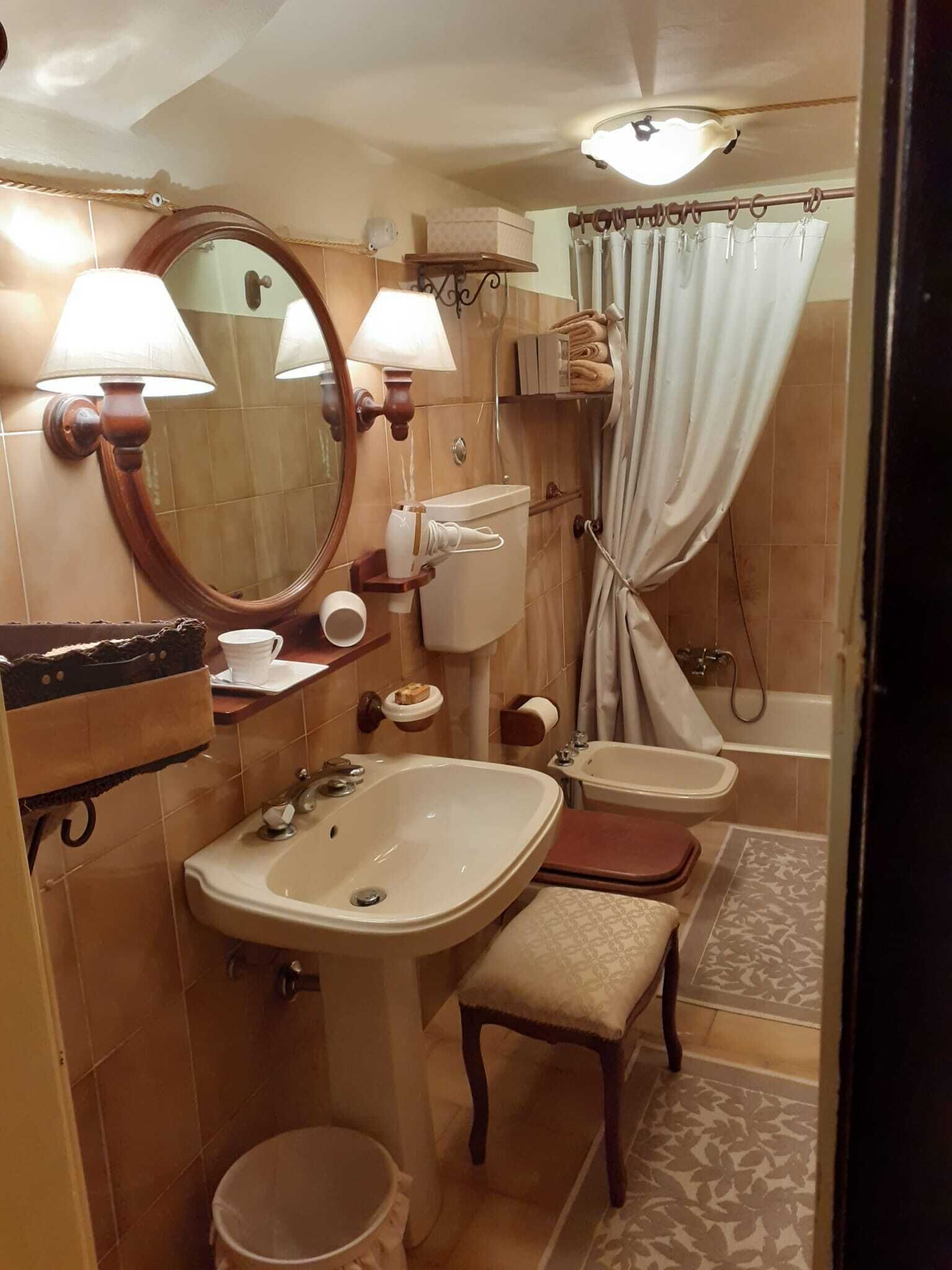 A bathroom with a sink, mirror, toilet, and shower.
