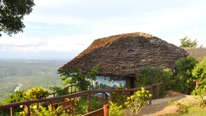 A thatched-roof hut with a wooden railing and a sign indicating it is for residents only.
