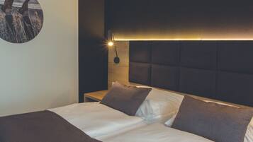 Una habitación de hotel con una cama, una mesita de noche, una lámpara de pared y un cuadro redondo en la pared.