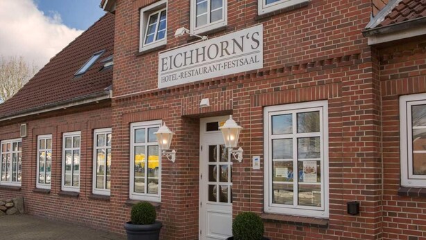 Un edificio de ladrillo con un letrero que dice "EICHHORN'S HOTEL-RESTAURANT-FESTSAAL".