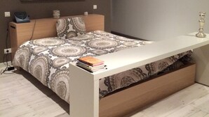 A modern bedroom with a bed, bedside table, and a wall-mounted shelf. - Loft Zen Bordeaux (Bordeaux)