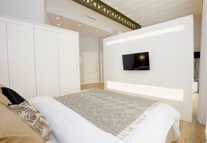 A modern bedroom with a bed, a TV mounted on the wall, and a wardrobe. - L'Aguila Apartments Turismo de Interior  (Palma de Mallorca)