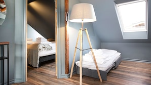 A bedroom with a bed, a standing lamp, and a window. - Iðunn Apartments by Heimaleiga (Reykjavik)