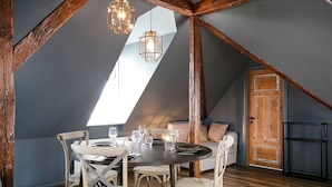 A dining area with a round table, chairs, and hanging lights. - Iðunn Apartments by Heimaleiga (Reykjavik)
