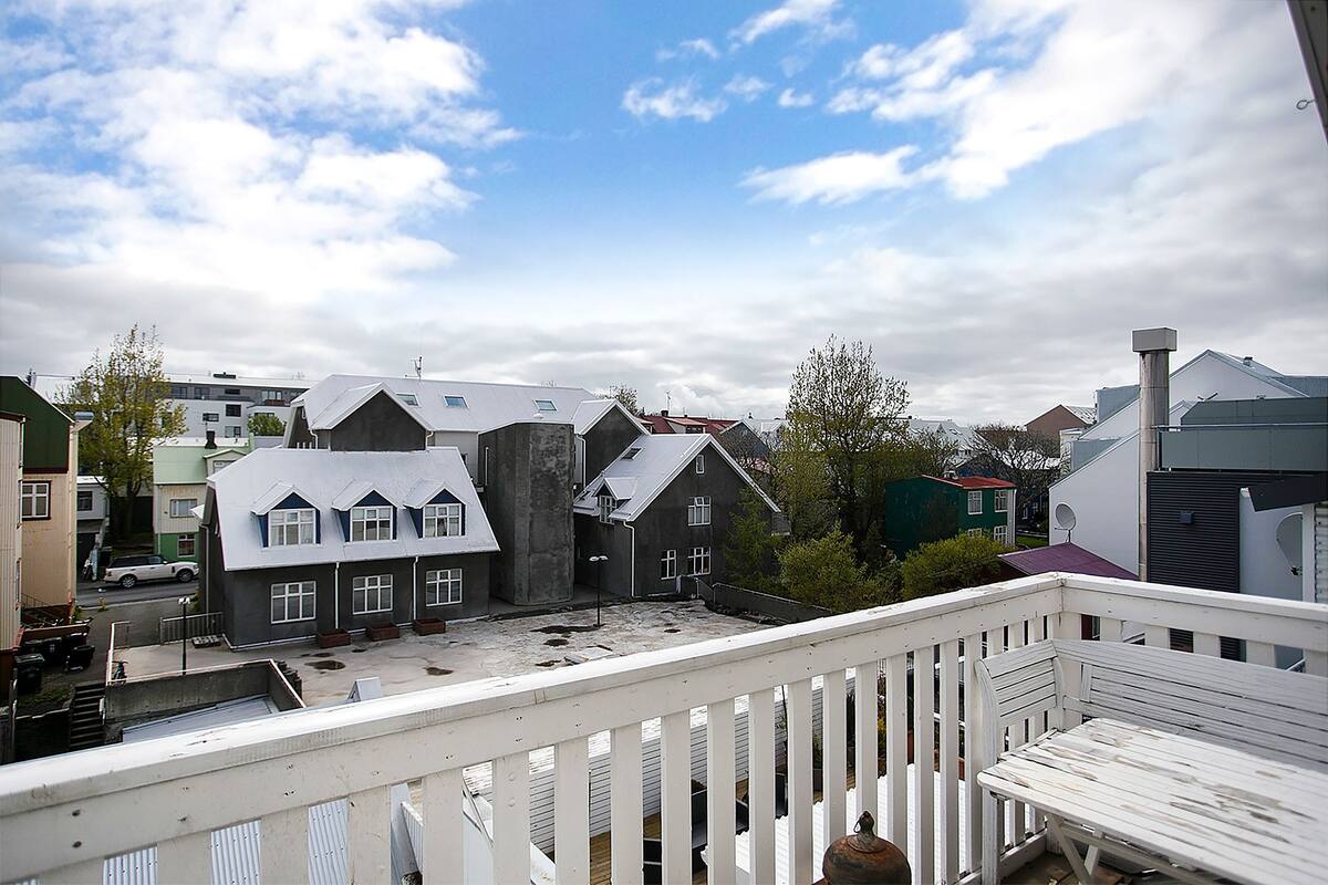 A residential area with houses, a balcony, and a clear sky.