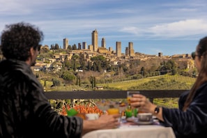 Ein Paar speist an einem Tisch mit Blick auf eine historische Stadtlandschaft.