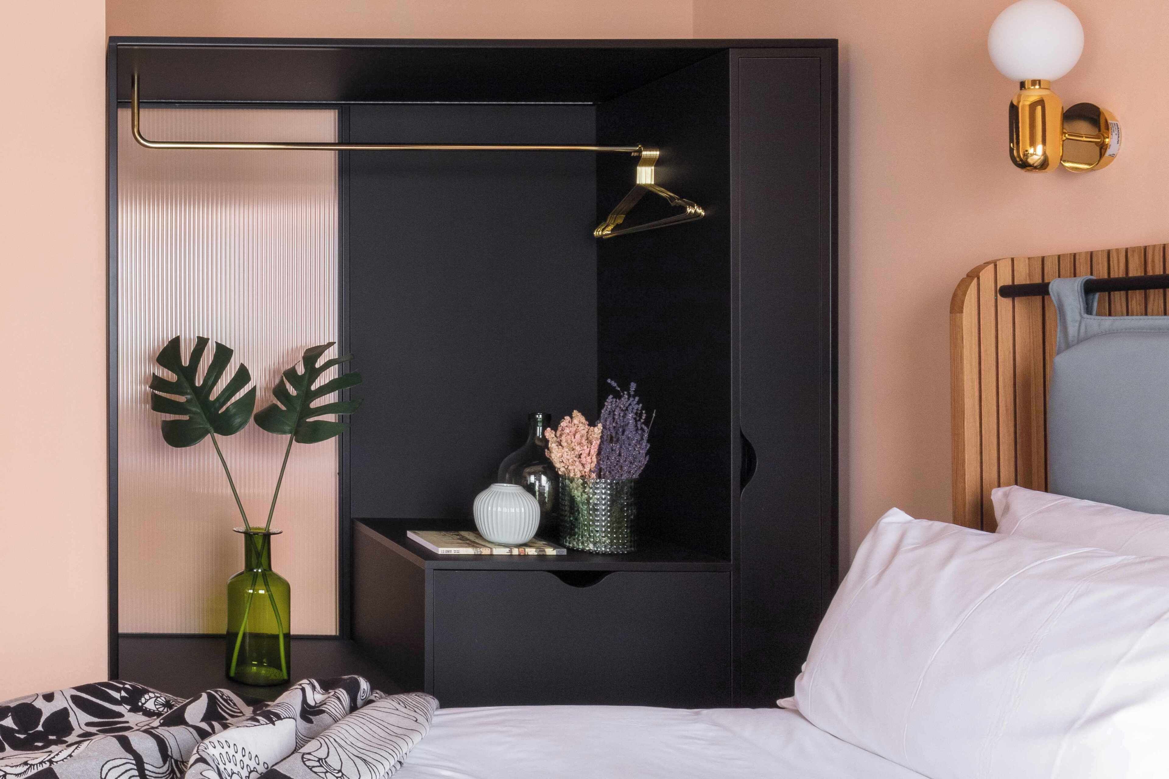 A bedroom with a bed, bedside table, lamp, and decorative items.